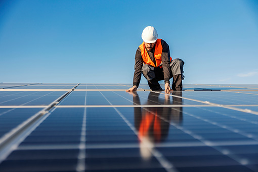 technicien qui pose des panneaux solaires sur un toit